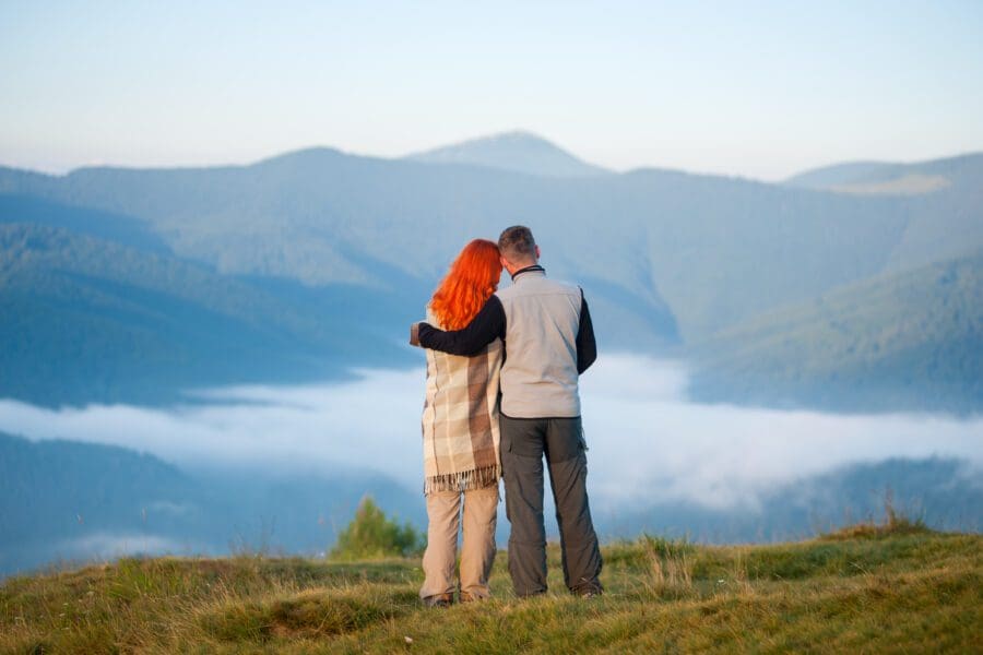 A couple standing at the edge of a vista contemplating their future